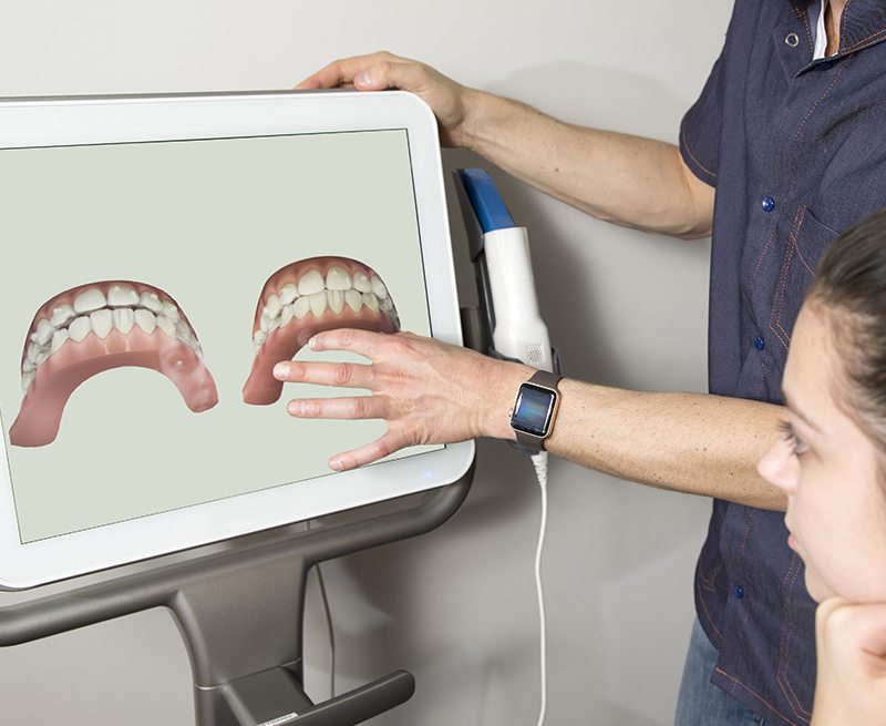 Dentist showing a patient digital images of their teeth using advanced dental technology