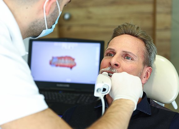 Dentist taking digital dental impressions of a patient