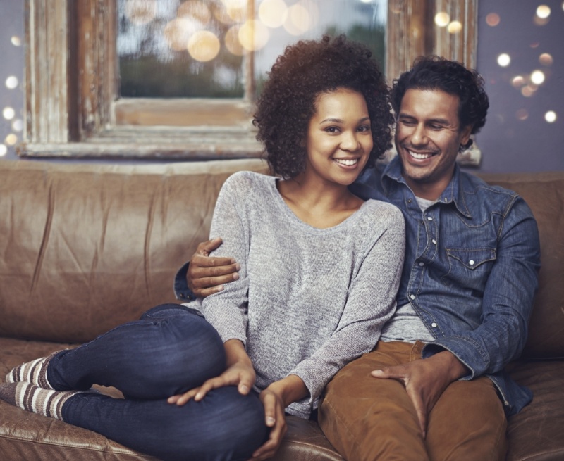 Man and woman sitting on leather couch together