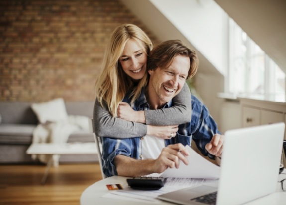 Man and woman reading dentist reviews on laptop